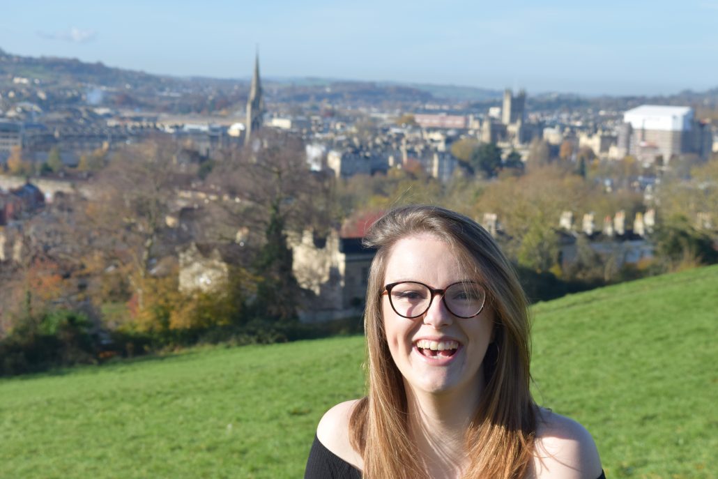Eve smiling on a hillside with Bath in the background
